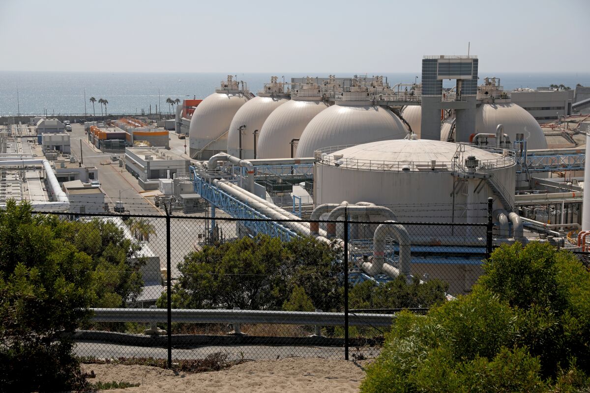 Tanks at a water reclamation plant with the ocean in the distance