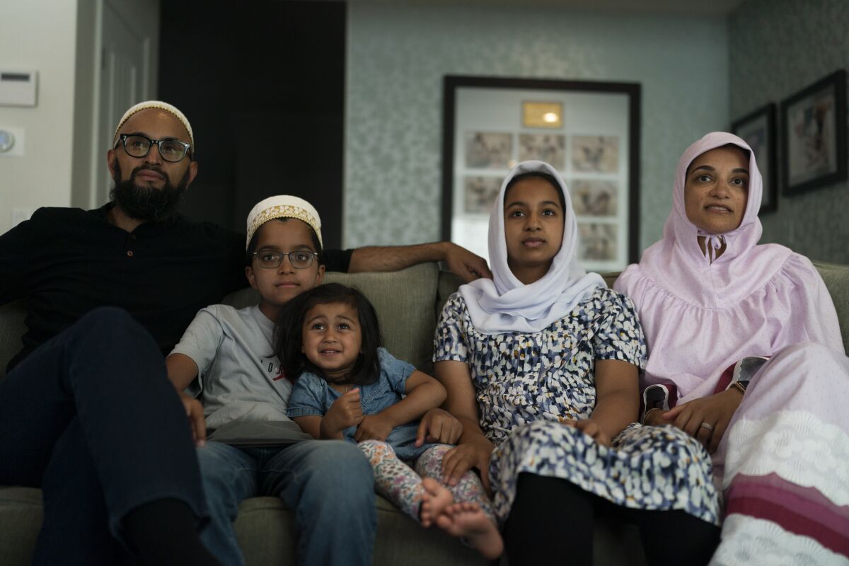 The Zakir family, from left, father Yusuf, son Burhanuddin, Yusuf's niece, Insiya Maimoon; daughter Jumana, mother Fareeda, watch an episode of "Ms. Marvel" in Anaheim, Calif., Friday, July 8, 2022. Jumana knows who she is going to be for Halloween this year. Her new favorite superhero is a lot like her – female, teen, Muslim, American and “totally awesome.” (AP Photo/Jae C. Hong)