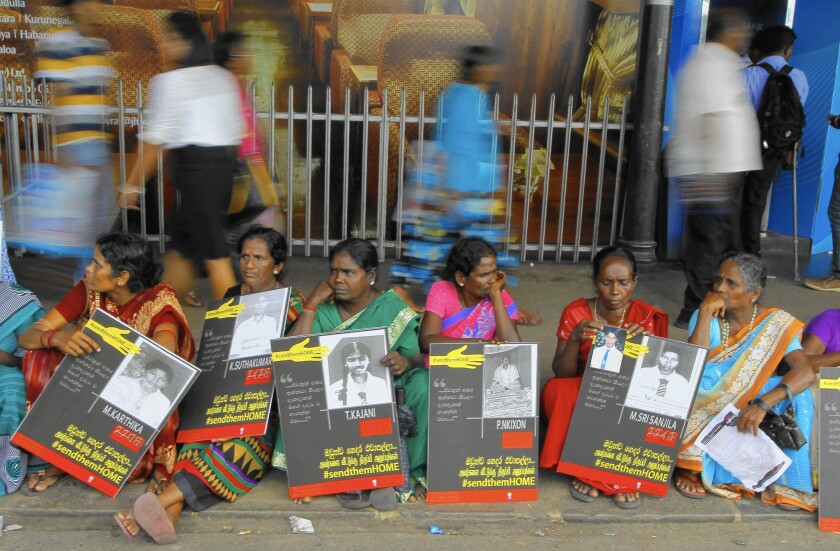 Sri Lankan ethnic Tamil women hold portraits of their missing relatives during a protest in Colombo in April 2015.