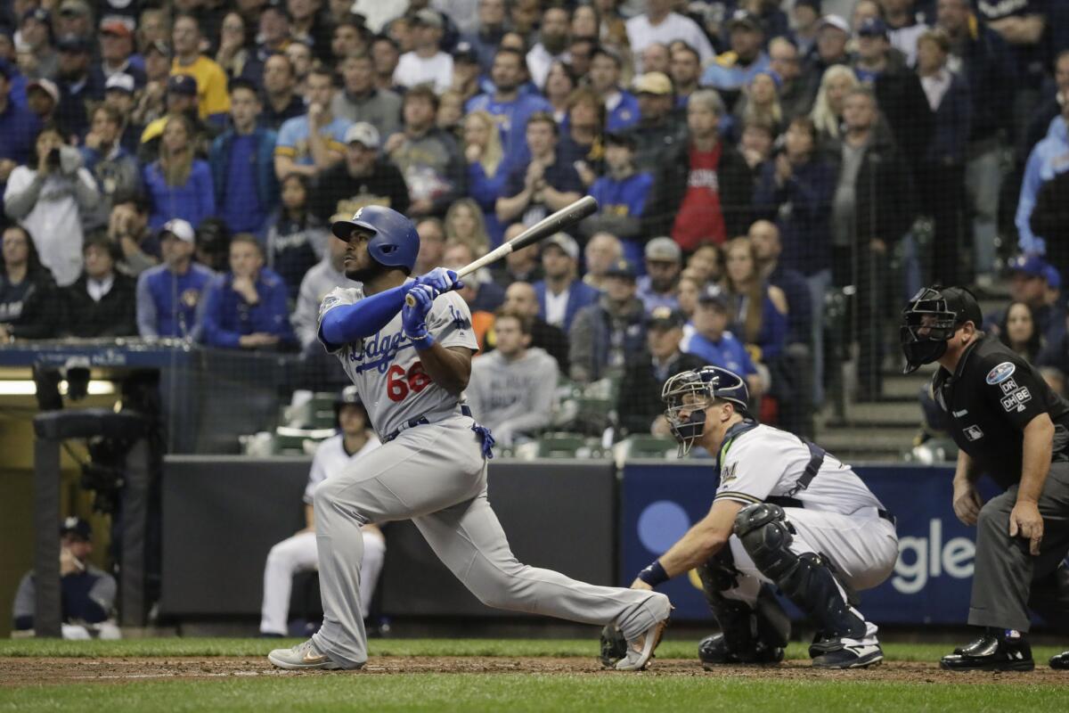 A Dodgers baseball player swings the bat