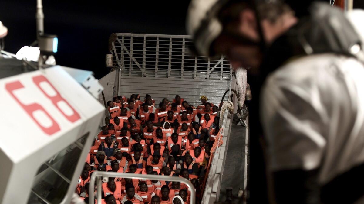 A handout photo made available by the NGO SOS Mediterranee shows the sea rescue of 629 migrants who were taken to the Aquarius boat.