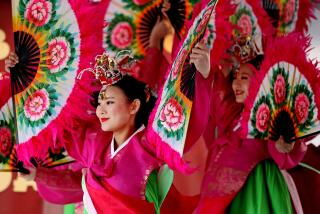 ALHAMBRA, CA - JANUARY 29: Dancers with the Korean Dance Academy wearing traditional garb perorm the fan dance at The Alhambra Lunar New Year Festival along the 200 block of Main St. in downtown on Sunday, Jan. 29, 2023 in Alhambra, CA. Year of the Rabbit. The festival, since 1993, will feature all-day entertainment with lion dancers, live candy sculpting, live Chinese demonstrations, food, merchants abd activity booths, in the heart of Downtown Alhambra. (Gary Coronado / Los Angeles Times)