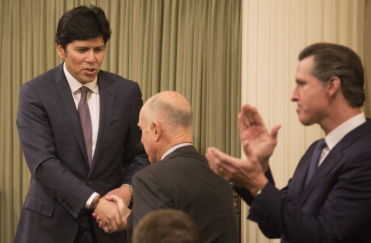 California Senate President Pro Tem Kevin de León, left, and Lt. Gov. Gavin Newsom, right, applaud at Gov. Jerry Brown's State of the State speech in January. De León and Newsom are feuding over gun control, something they both support.