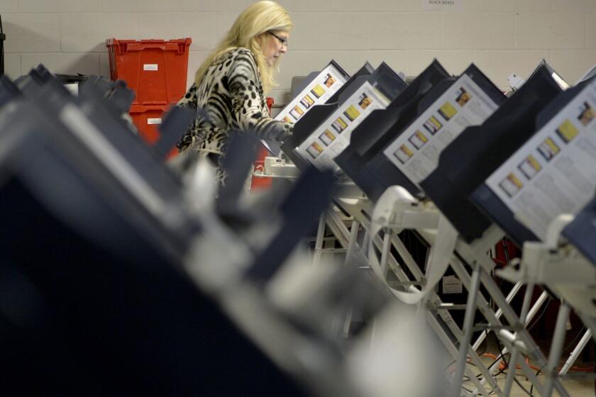 Richmond County Board of Elections Executive Director Lynn Bailey tests voting machines Monday, Nov. 26, 2018 in Augusta, Ga., as she prepares for advance voting in the upcoming runoff election. (Michael Holahan/The Augusta Chronicle via AP)
