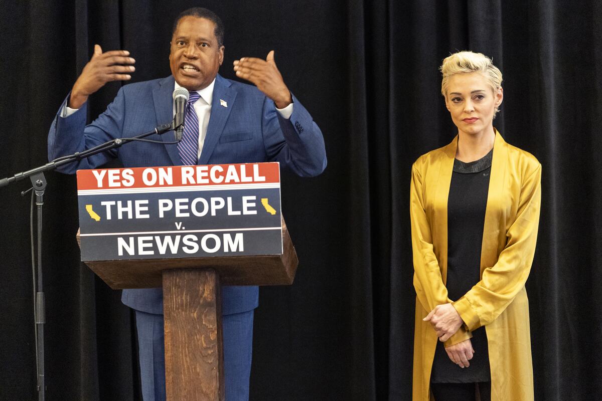 Republican conservative radio talk show host Larry Elder with former actress and activist Rose McGowan hold a news conference at the Luxe Hotel Sunset Boulevard in Los Angeles Sunday, Sept. 12, 2021. Elder is running to replace Democratic Gov. Gavin Newsom in the Sept. 14 recall election. McGowan, who is known for her role in the "Scream" movie franchise, was one of the earliest of dozens of women to accuse Hollywood producer Harvey Weinstein of sexual misconduct, making her a major figure in the #MeToo movement. (AP Photo/Damian Dovarganes)