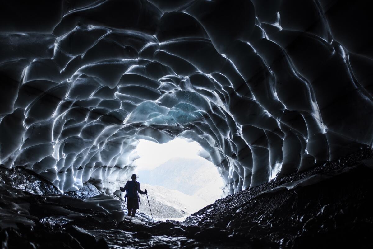 A man stands in a glacier cave at the Sardona glacier in Vaettis, Switzerland. 