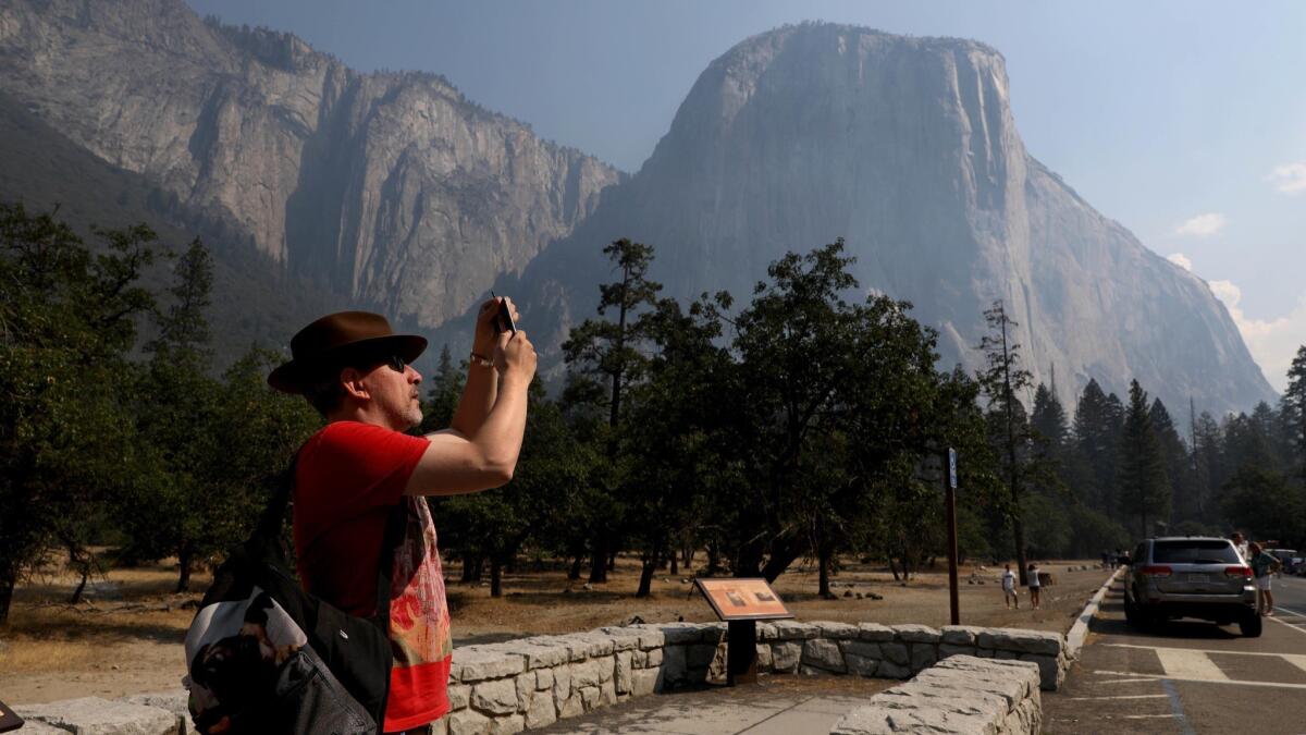Steve Maddison of Holland photographs El Capitan upon Yosemite National Park's reopening Aug. 14 as firefighters further contained the Ferguson fire.