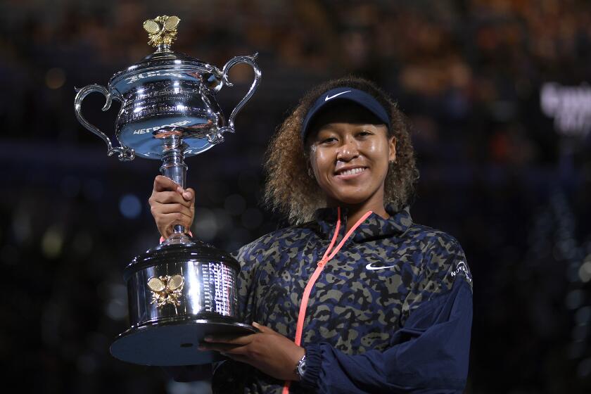 Japan's Naomi Osaka holds the Daphne Akhurst Memorial Cup aloft after defeating United States.