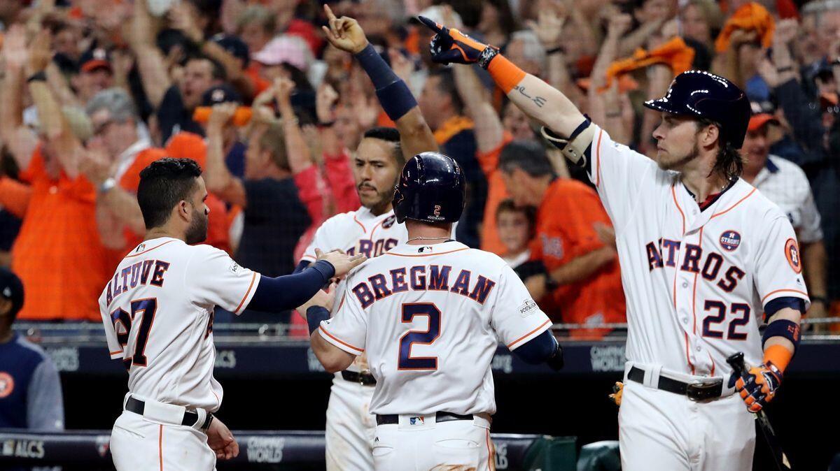 Houston Astros' Alex Bregman (2) celebrates with his teammates after scoring off of a Brian McCann RBI double against the New York Yankees during the fifth inning in Game 6 of the ALCS on Friday.