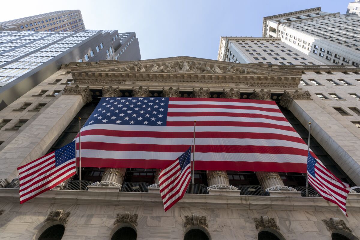 FILE - In this Monday, Sept. 21, 2020, file photo, a giant American Flag hangs on the New York Stock Exchange. U.S. stocks are climbing Monday, Nov. 2, 2020, kicking off a potentially turbulent stretch for markets, as Wall Street recovers some of its sharp sell-off from last week. (AP Photo/Mary Altaffer, File)