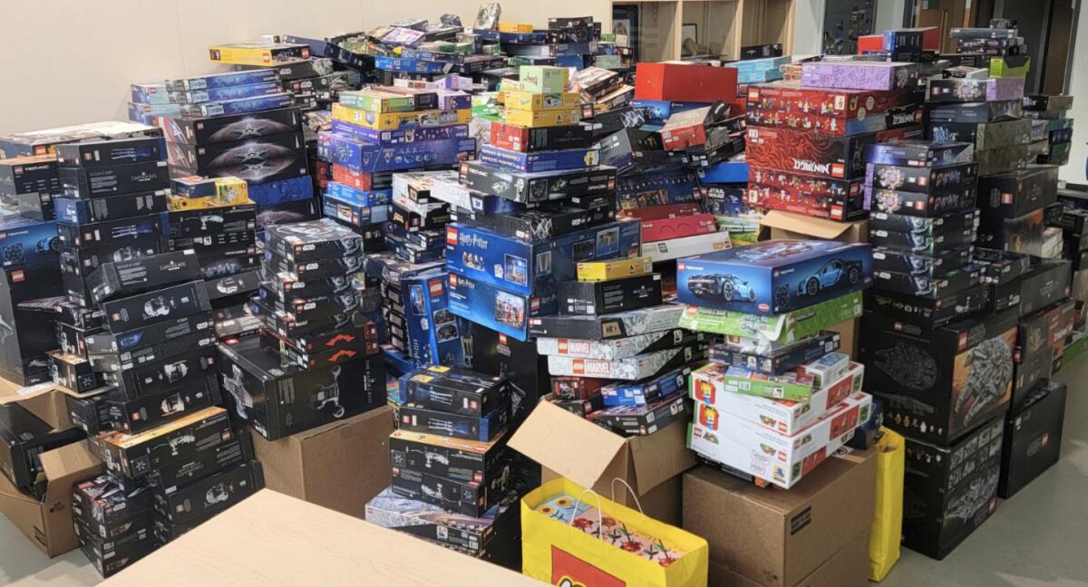 Stacks of boxed Lego kits fill a room. 
