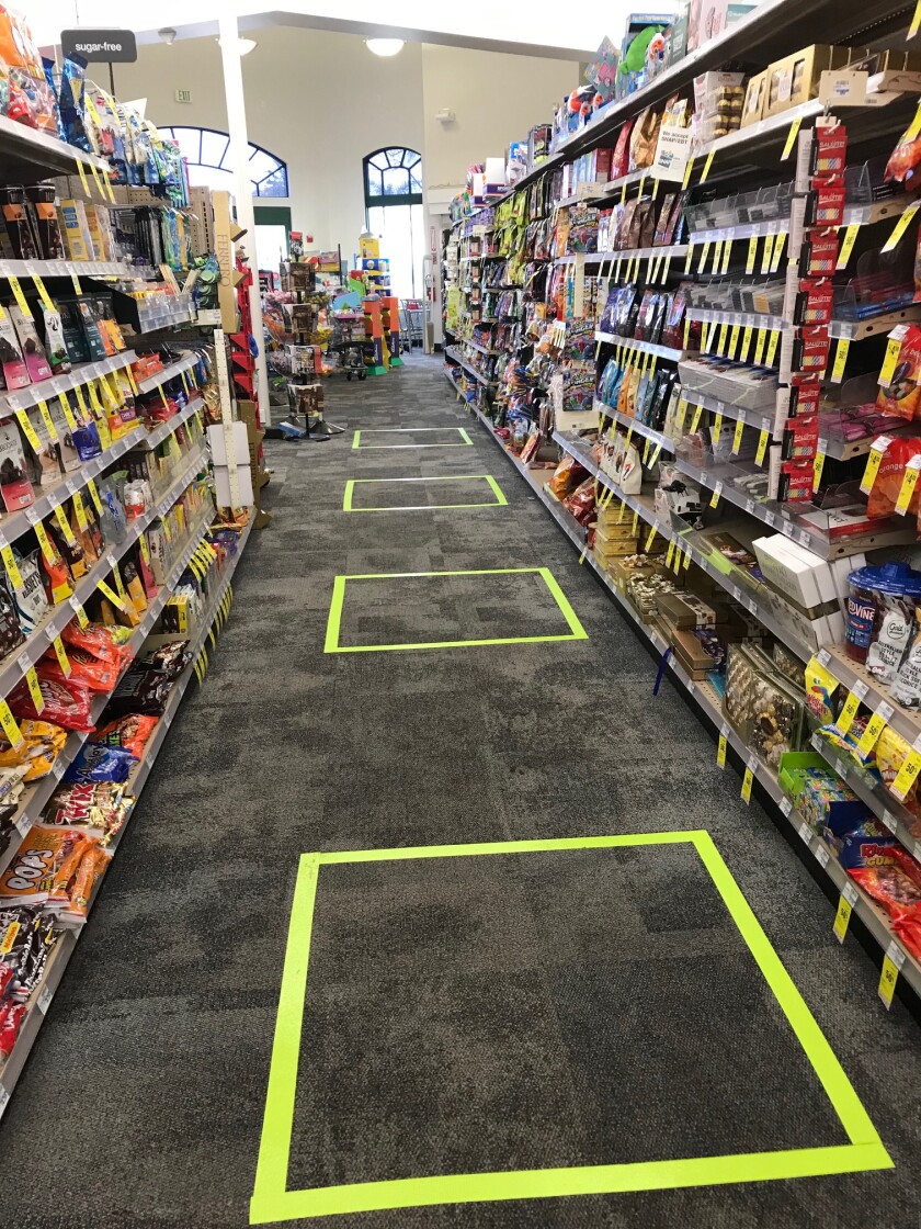 Boxes are marked on the floor of a local store to show proper social distancing.