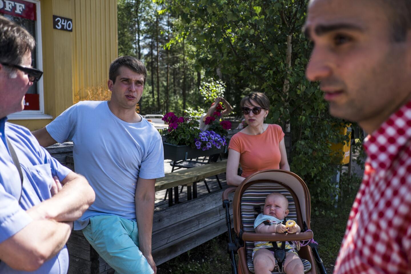 Sergei Kotelnikova, second from left, is shown with his wife, Anya, and their daughter, Emily, at a refugee center in Konnunsuo, Finland. The family fled Russia, as did Alin Tovmasian, right, after Jehovah's Witnesses were labeled extremists there and their faith was banned. At left is Harri Ikonen, a member of the Jehovah’s Witnesses community in Konnunsuo.