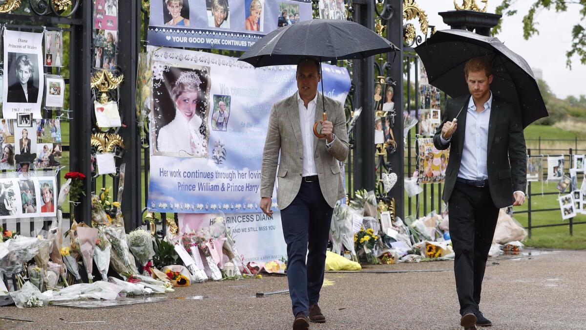 Britain's Prince William and Prince Harry walk away after looking at tributes left by members of the public outside Kensington Palace in London to mark the 20th anniversary of the death of their mother, Diana, Princess of Wales.