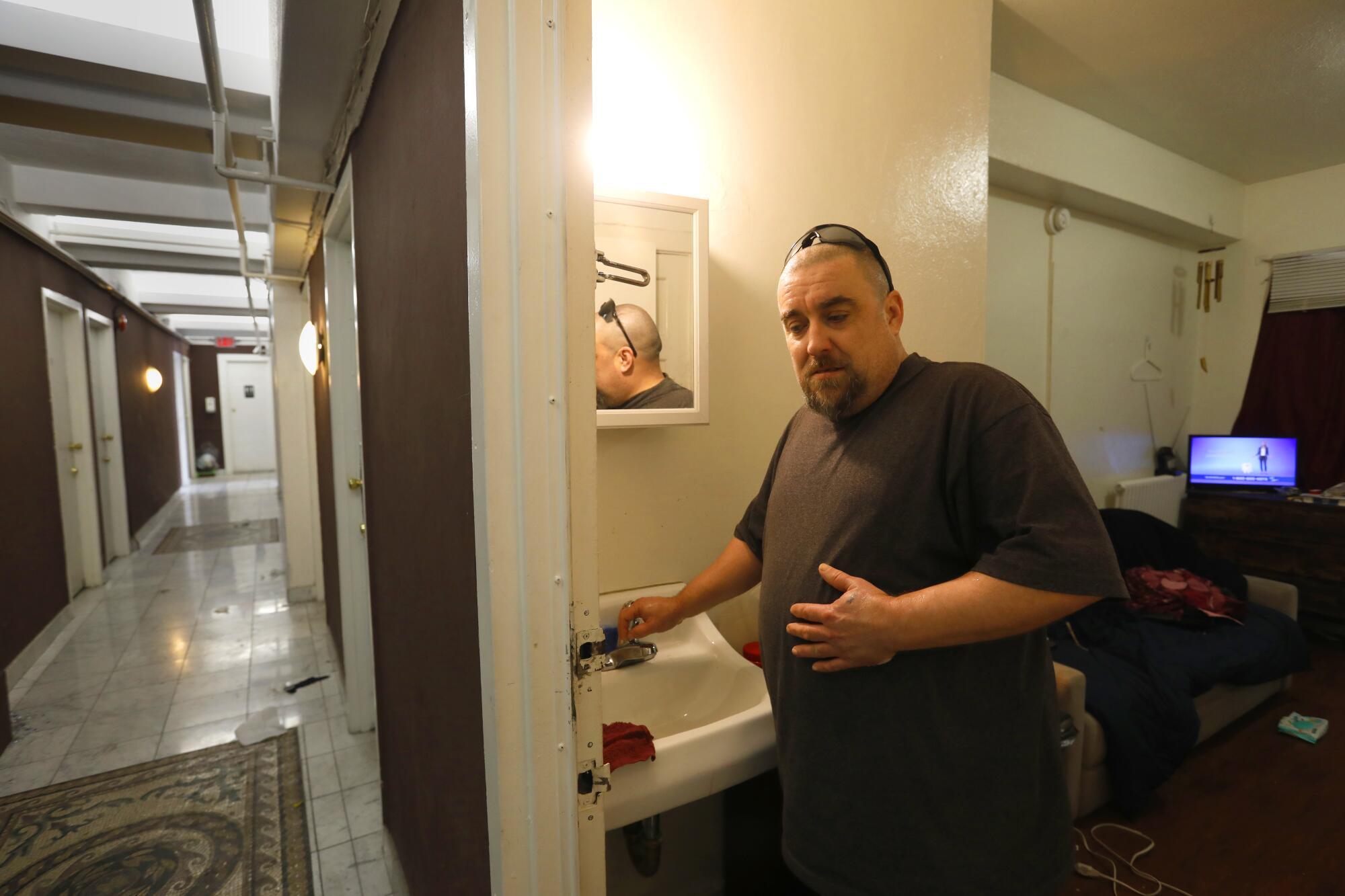 A man stands in his apartment.