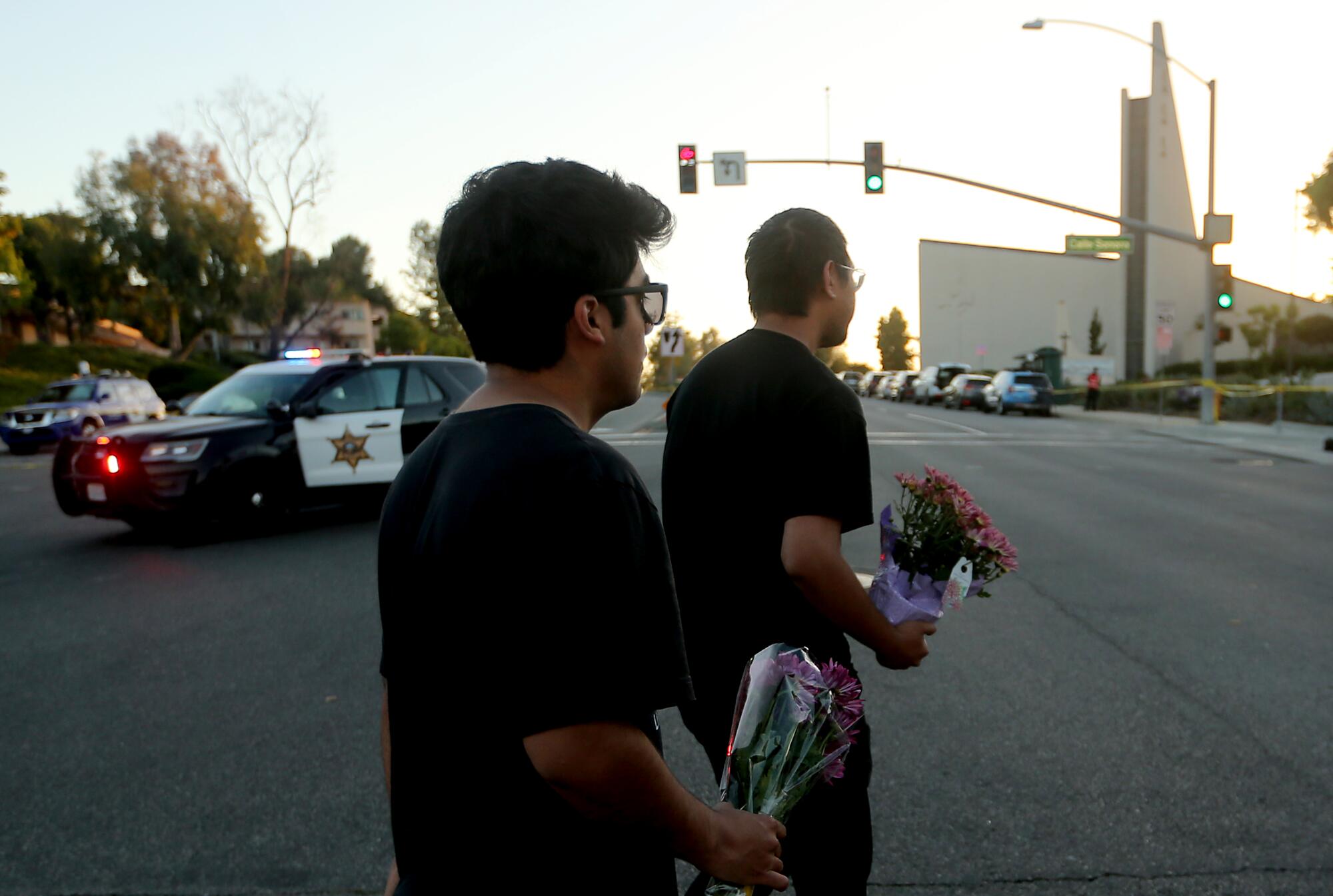Two people holding flower bouquets while walking