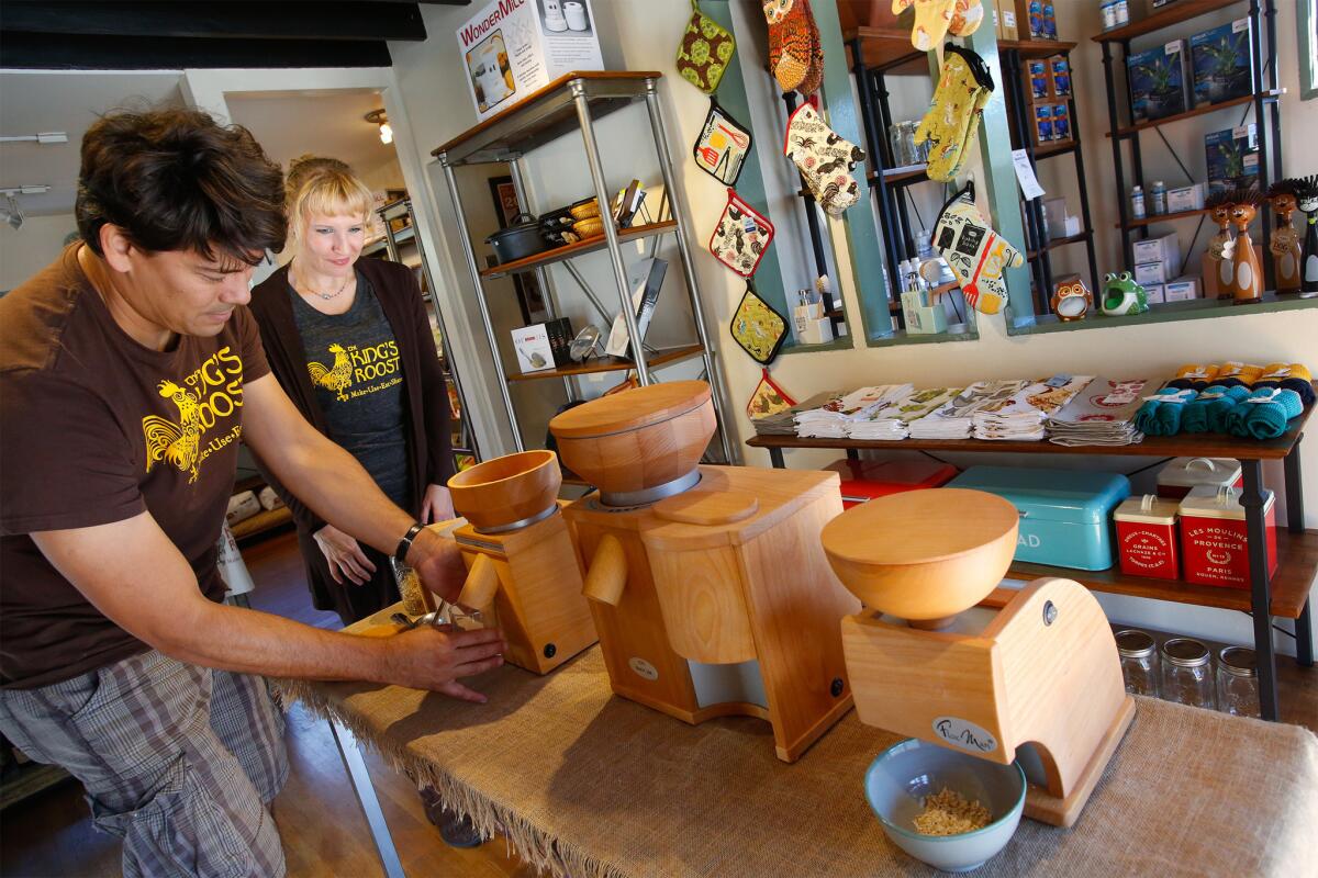 Roe Sie, left, demonstrates a grain mill as his wife, Trish Sie, looks on at King's Roost, a new homesteading store in Los Feliz.