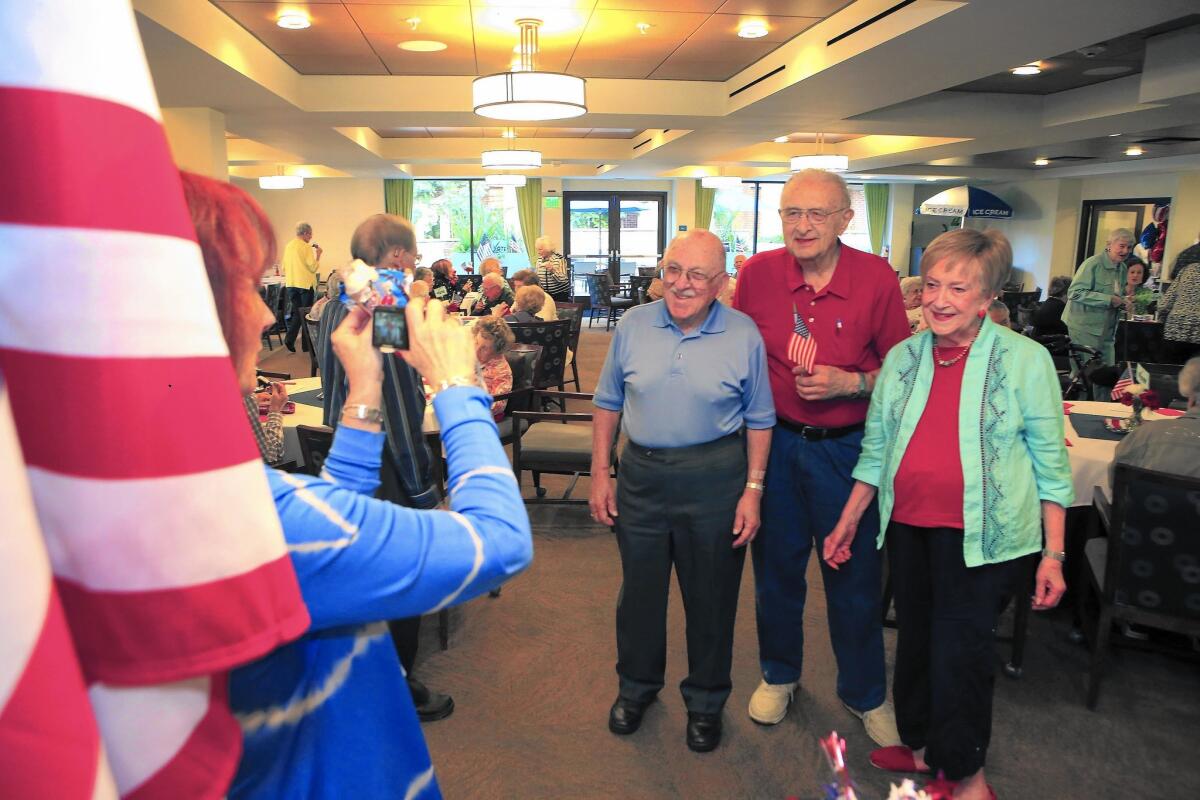 Activities director Shelly Smilen takes a photo of Lee Weinstein, left, Harry Shragg and former L.A. Councilwoman Joy Picus at the Fountainview independent-living apartment complex in Reseda on Nov. 5. The trio organized a voter turnout campaign there.