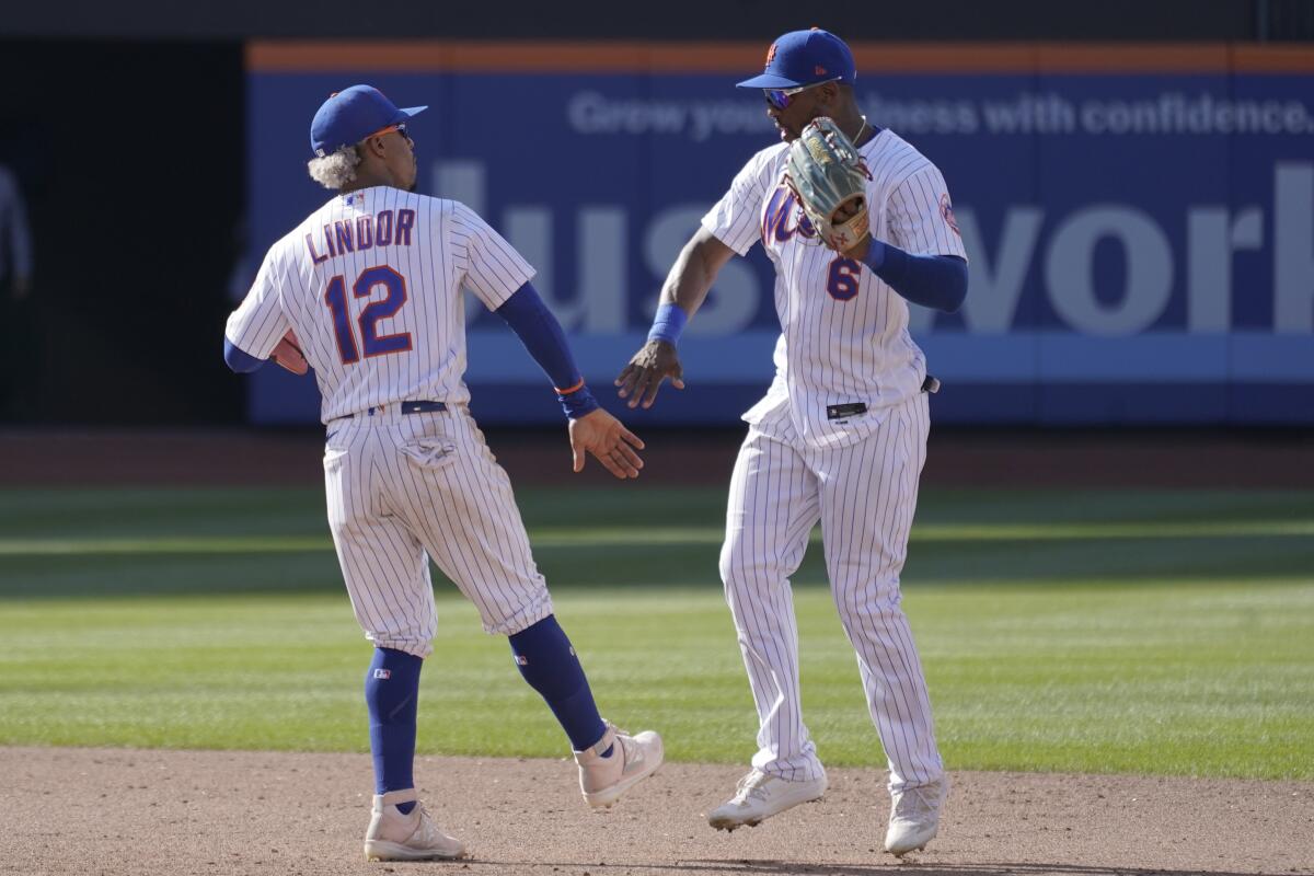 New York Mets' Francisco Lindor (12) and Starling Marte (6) celebrate after they defeated the Atlanta Braves in the first game of a baseball doubleheader, Saturday, Aug. 6, 2022, in New York. (AP Photo/Mary Altaffer)