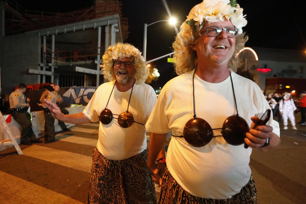 Scott Monson, right, and Brian Hogan, join the thousands of costumed revelers at the annual Halloween Carnaval.