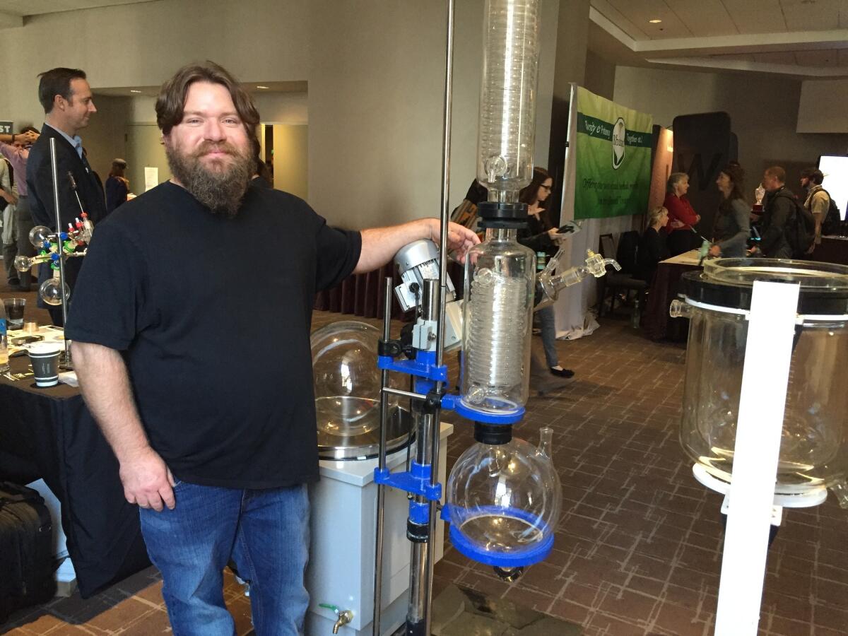 Robert Gaither of Genius Extraction Technologies with the cold-extraction machine his wife, Brenna, a biochemist, developed at the New West Summit cannabis conference.