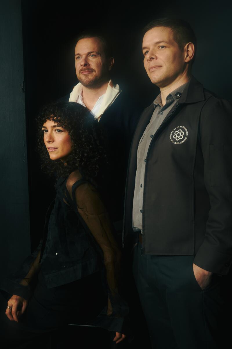 Three people pose for a portrait.