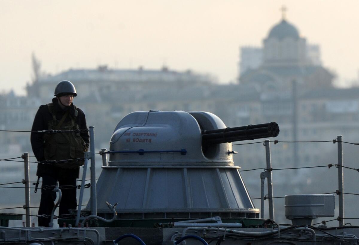 A seaman stands guard aboard the Ukrainian navy ship Slavutich in the harbor of Sevastopol, Ukraine. The Ukrainian flag has never been fully embraced in Sevastopol and its famed port, home to Russia's Black Sea fleet since the time of the czars.