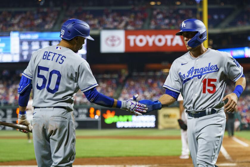 Los Angeles Dodgers' Austin Barnes, right, celebrates his run on the single by Gavin Lux with Mookie Betts, left, during the eighth inning of a baseball game against the Philadelphia Phillies, Saturday, May 21, 2022, in Philadelphia. The Dodgers won 7-4. (AP Photo/Chris Szagola)