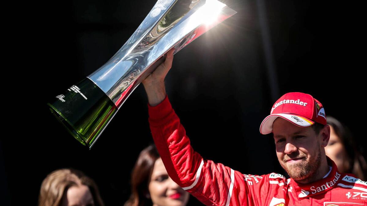 Formula One driver Sebastian Vettel raises the trophy after winning the Brazilian Grand Prix on Sunday.