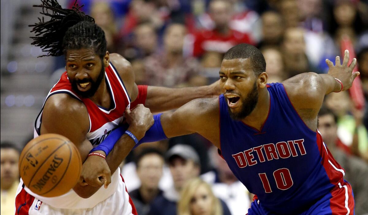 Wizards forward Nene and Pistons forward Greg Monroe (10) go after a loose ball in the second half Saturday.