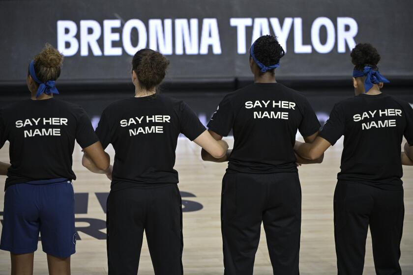Minnesota Lynx players lock arms during a moment of silence in honor of Breonna Taylor before a WNBA basketball game against the Connecticut Sun, Sunday, July 26, 2020, in Bradenton, Fla. (AP Photo/Phelan M. Ebenhack)