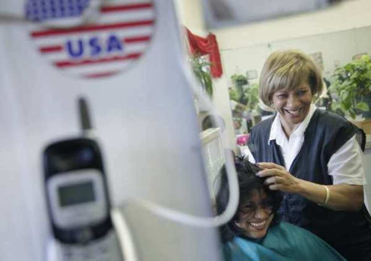 Milagros Rodriguez, who is originally from the Dominican Republic, works with a customer at her salon, the Woodside Beauty Salon, in the Queens borough of New York.