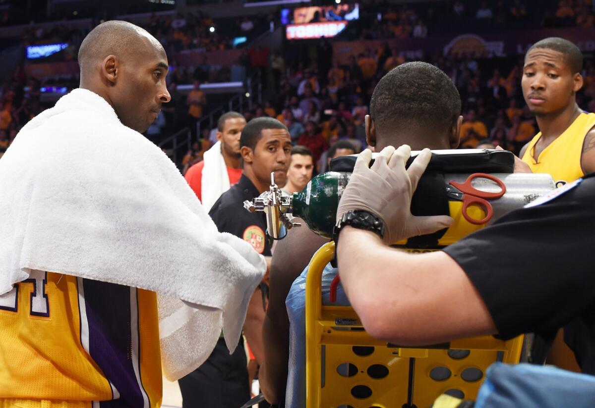 Lakers veteran Kobe Bryant comforts his rookie teammate Julius Randle after the power forward suffered a fractured right tibia in his NBA debut.