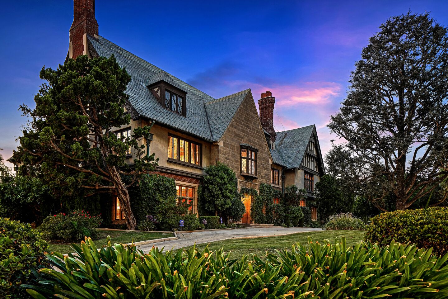 Exterior view of an English Tudor style mansion at sunset