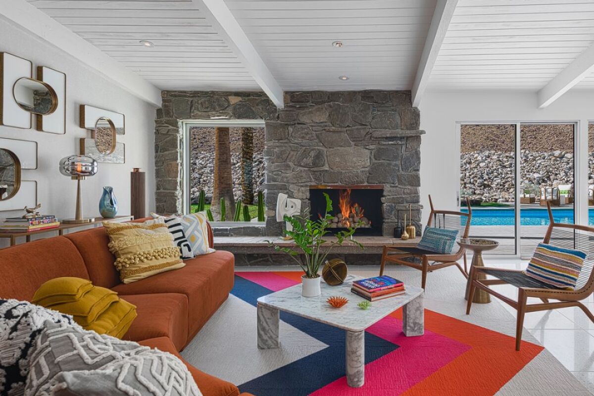 A living room, fireplace and pool.