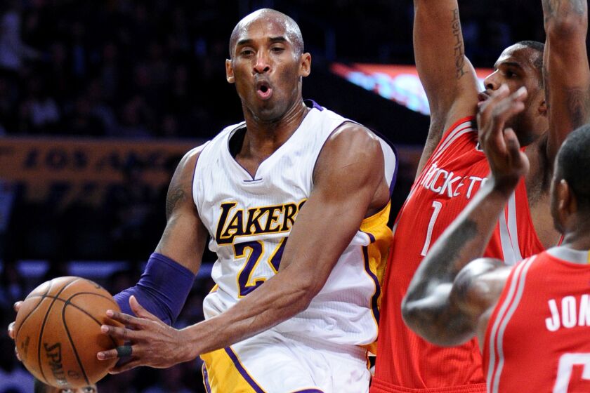Lakers forward Kobe Bryant looks to pass after driving to the basket against the Rockets in the first half.