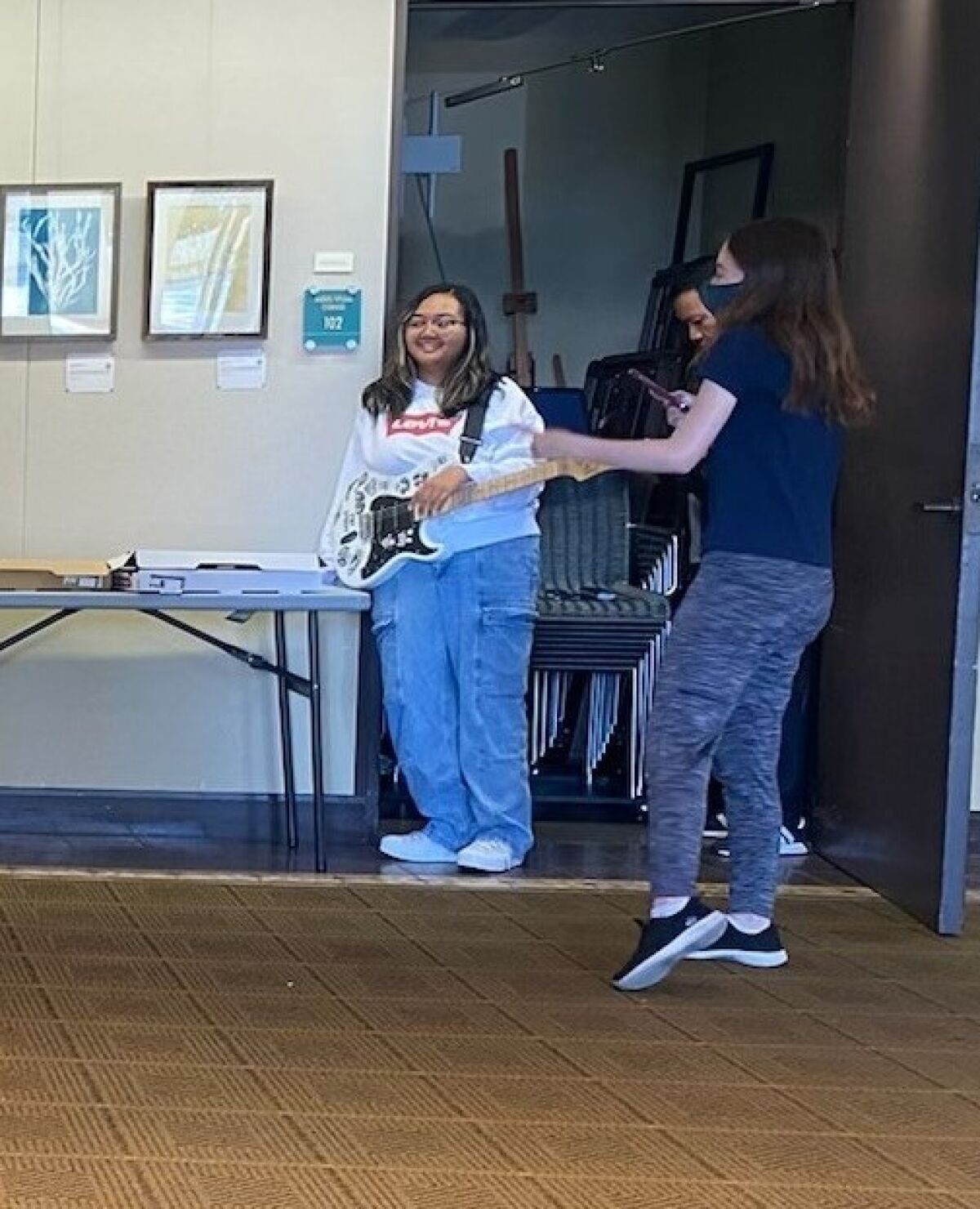 Carla Ayonque, 15, played at Teen Open Mic Night at the La Jolla Library. At right is Teen Troupe President Arianna Roberts.