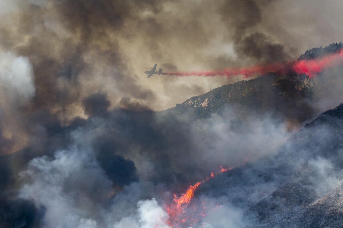 An air tanker drops retardant as a wildfire burns at a hillside in Yucaipa, Calif., on Saturday.