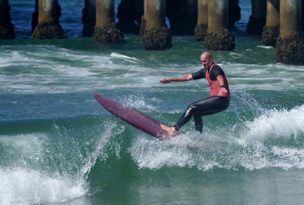 Taylor Jensen moved on to the longboard semifinals during the U.S. Open of Surfing, in Huntington Beach on Friday.