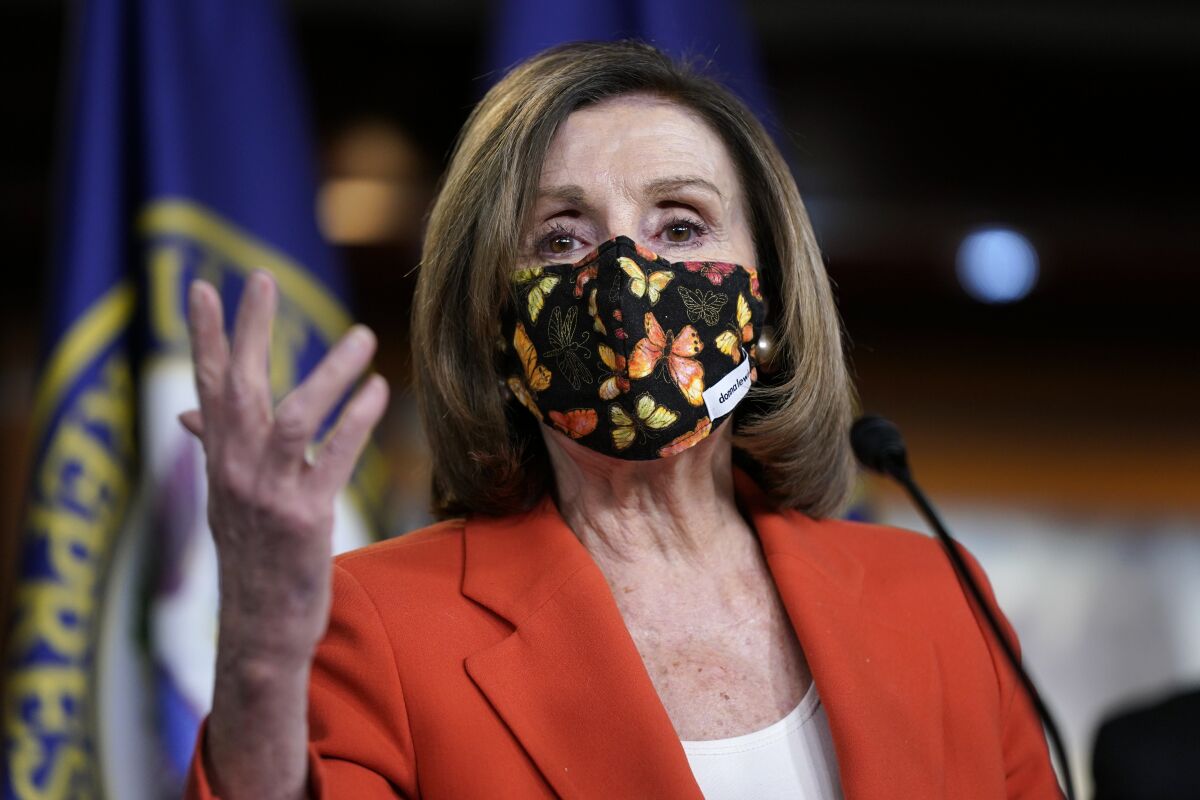 House Speaker Nancy Pelosi speaks with a mask on