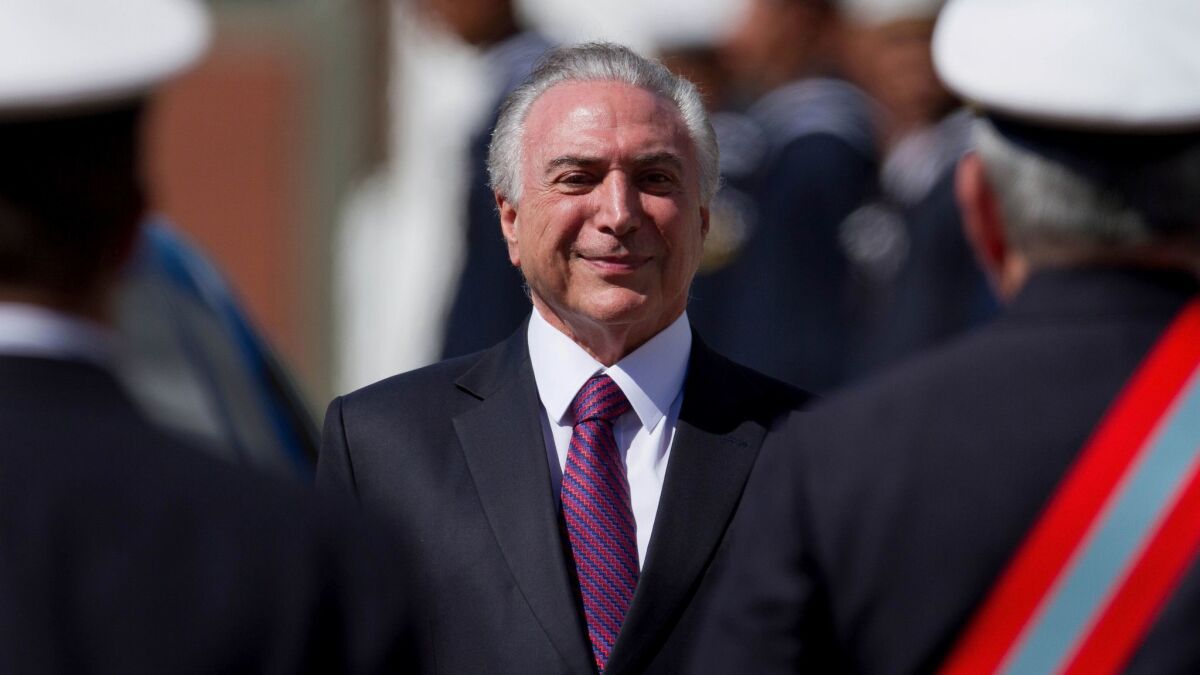 Brazilian President Michel Temer smiles as he receives military honors during a ceremony in Brasilia on Friday.