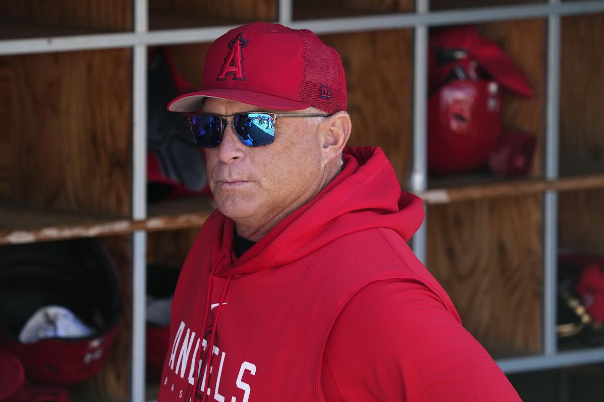 Angels manager Phil Nevin pauses in the dugout prior to the team's spring training game against the Dodgers.