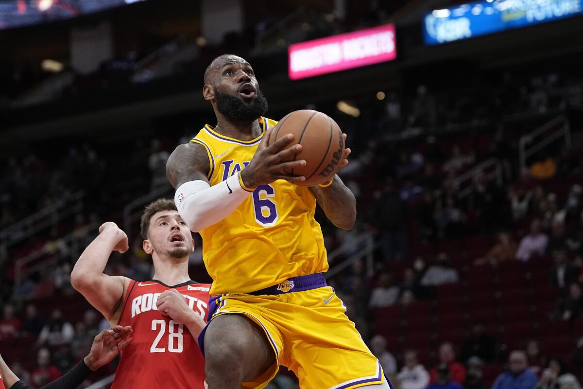 Lakers' LeBron James goes up for a shot as Houston Rockets' Alperen Sengun defends.