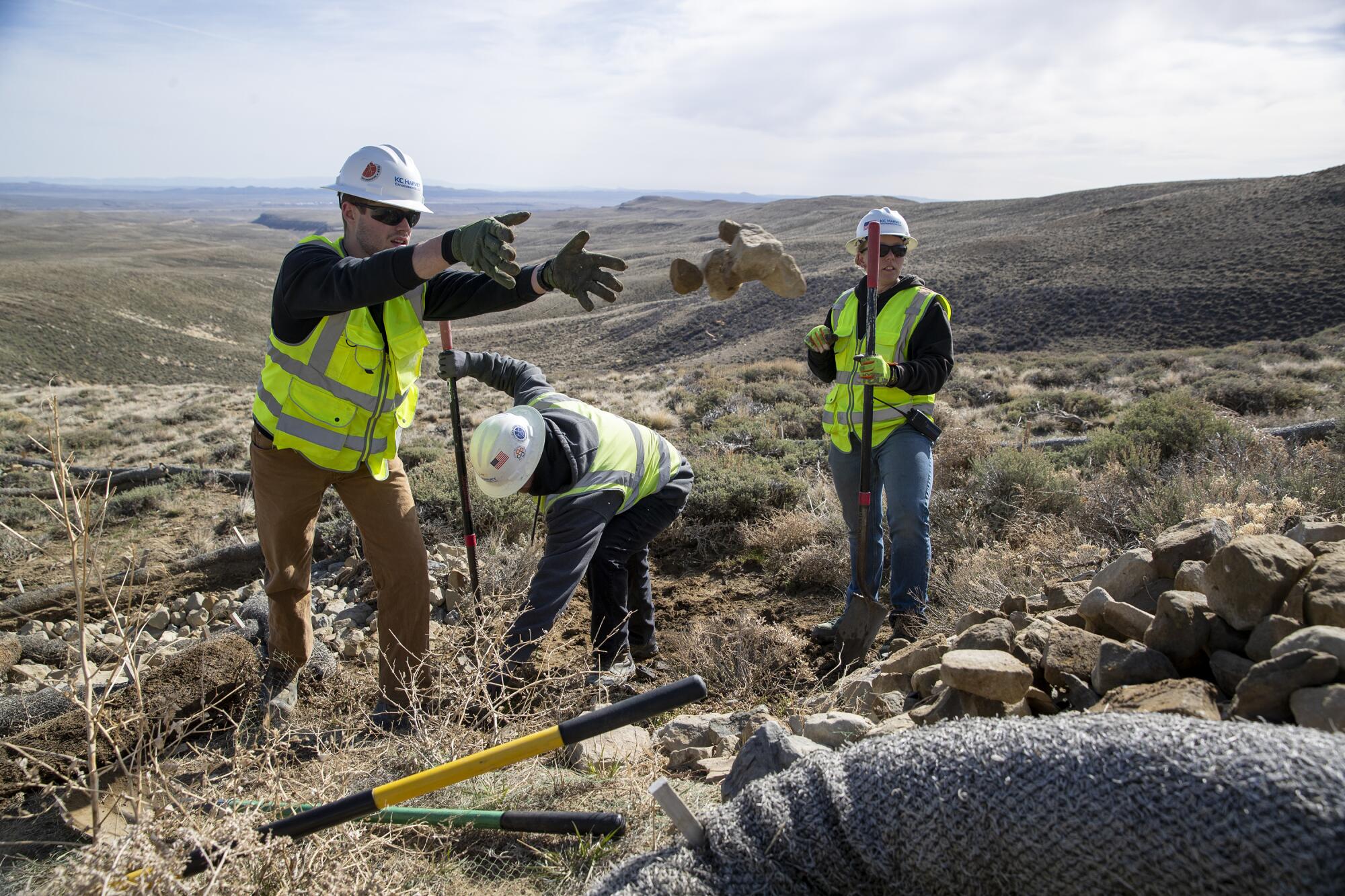 Wind farm construction workers place wood fiber and rocks to help prevent erosion.