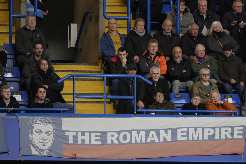 A banner in the colors of Russia's national flag depicting Chelsea soccer club owner Roman Abramovich and reading "the Roman Empire" is shown during the English Premier League soccer match between Chelsea and Newcastle United at Stamford Bridge stadium in London, Sunday, March 13, 2022. (AP Photo/Kirsty Wigglesworth)