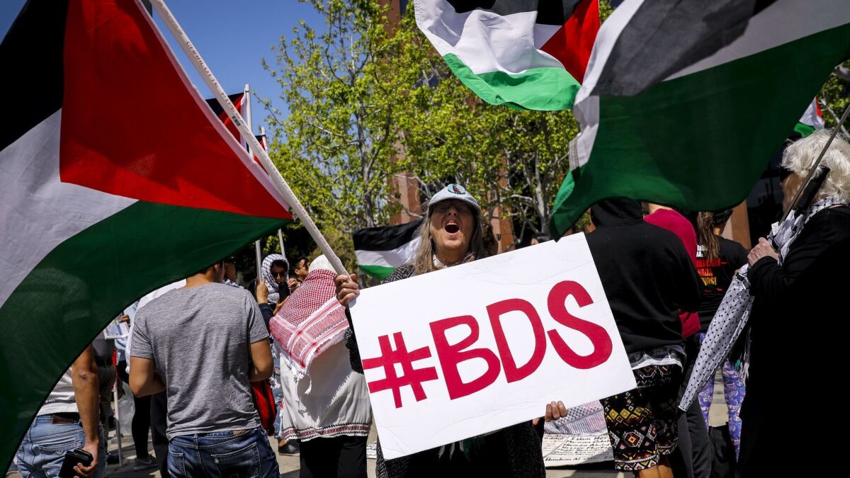 A woman yells while holding a sign "#BDS," referring to "Boycott, Divestment, Sanctions," in front of the Israeli Consulate in Los Angeles on May 14.
