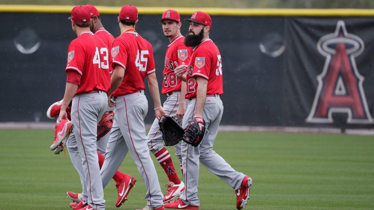 Angels pitchers leave the field together after a workout session during the first day of spring training camp. Left to right are Garret Richards (43), JC Ramirez, Tyler Skaggs (45), Andrew Heaney and Matt Shoemaker (52).