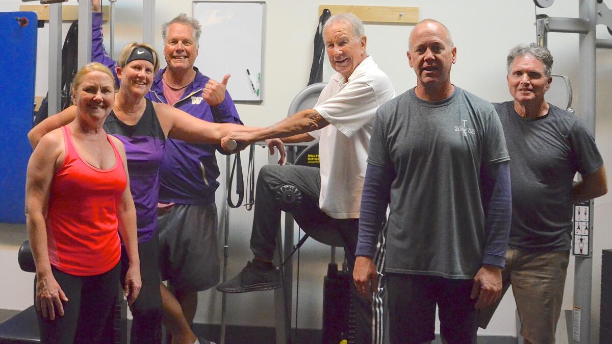 Kristi Peckham, Lea Campbell, Neil Ross, Harold Graham, 85, instructor Trevor Duncan and Brian Carroll, from left, attend a group personal training class at the Training Zone in Costa Mesa.
