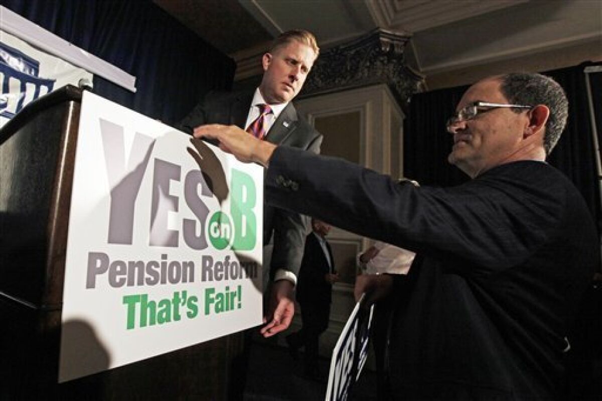 Supporters of Proposition B adjust a sign before a rally on election day in San Diego in this June 5, 2012 file photo.