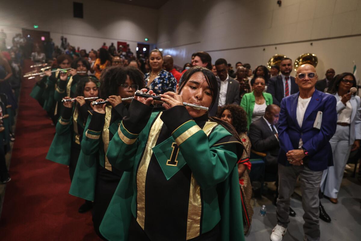 High school band members perform in an auditorium.